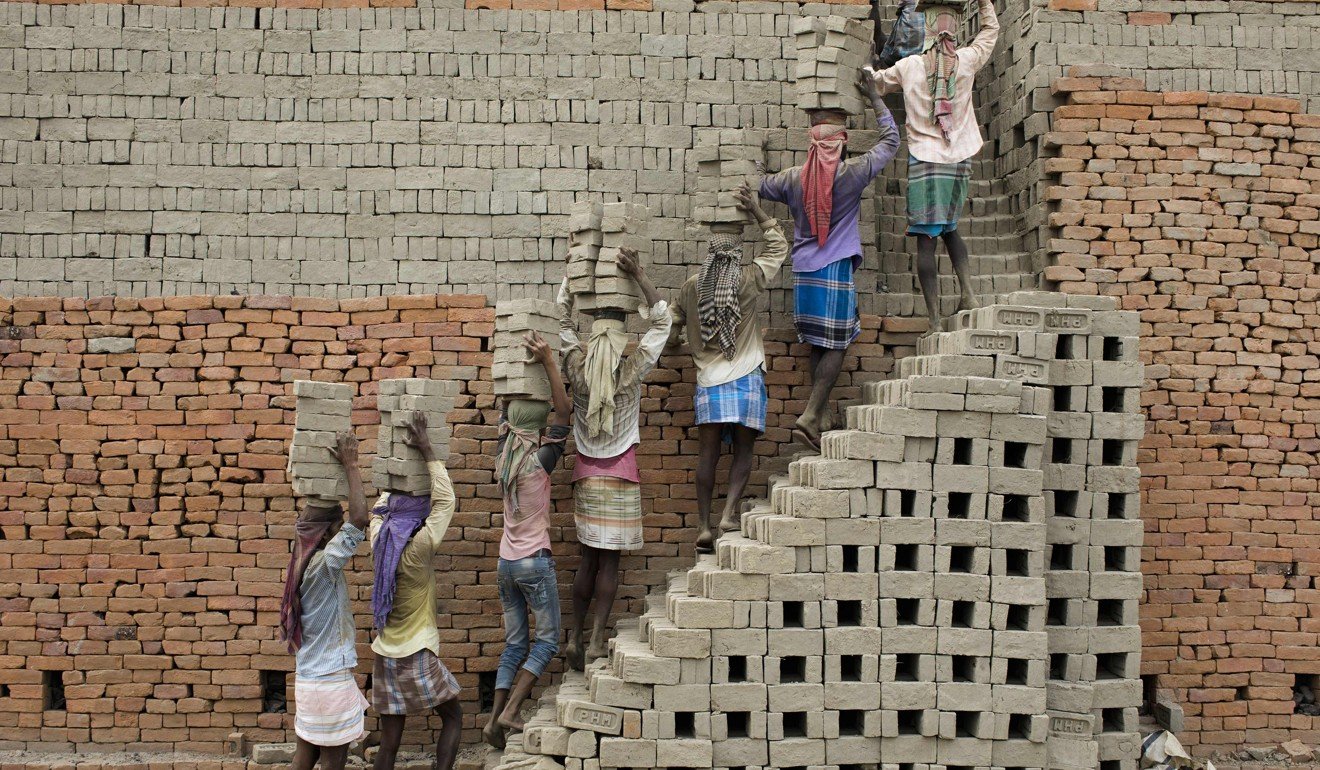 Indian labourers carry clay bricks to a kiln in Farakka. The construction industry is among India’s biggest employers. Photo: AFP