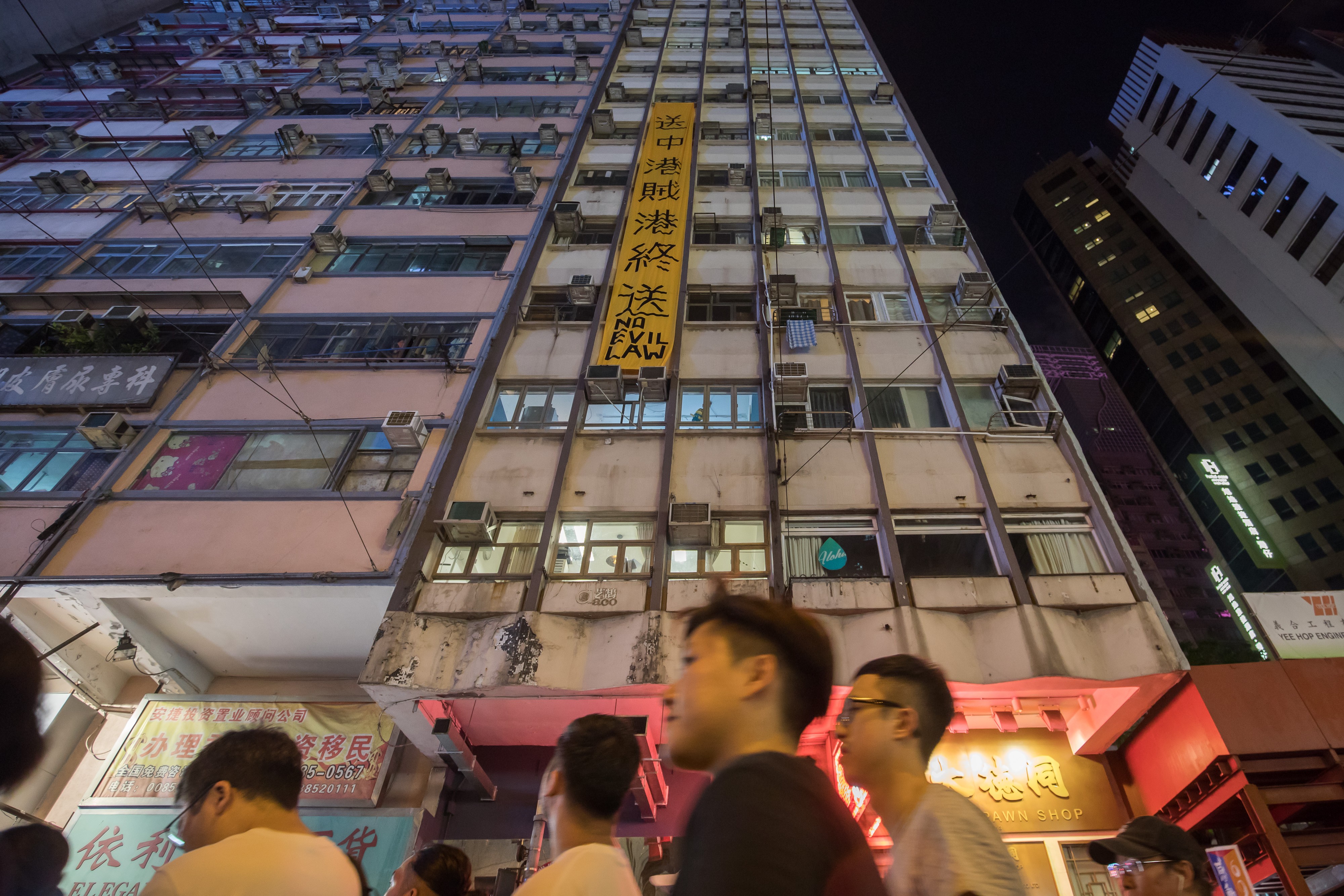 Protesters pass the Foo Tak Building during the first big march this summer against proposed extradition law changes in Hong Kong, on June 9. Photo: Bloomberg
