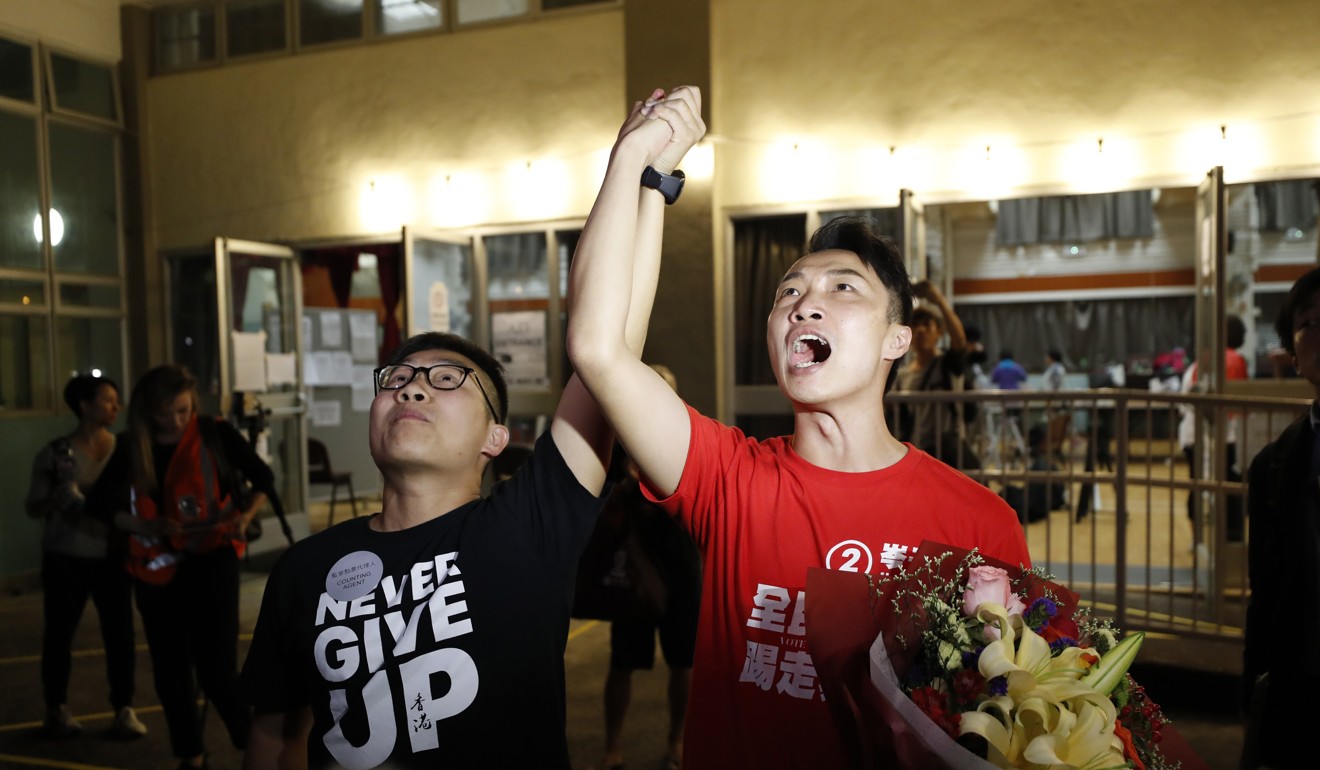 High-profile candidate Jimmy Sham, right, from the pro-democracy camp, celebrates his victory in the early hours of Monday. Photo: AP