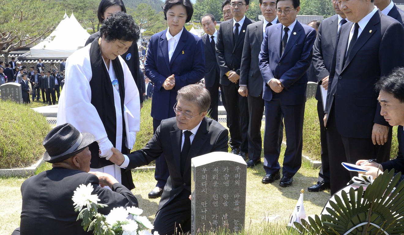 South Korean President Moon Jae-in (centre) consoles family members of the deceased at a memorial honouring the hundreds of citizens killed in Gwangju during the 1980 protests against the military junta of Chun Doo-hwan. Photo: AP