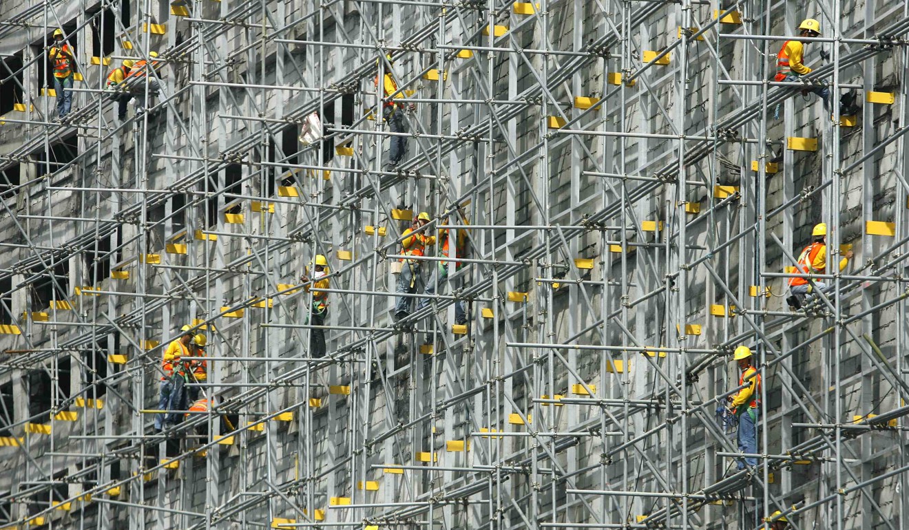 Employees work on a building under construction in Manila. Photo: Reuters
