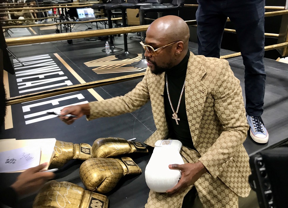 Floyd Mayweather signs gloves at the opening of the Mayweather Boxing + Fitness gym in Torrance, California. Photo: Reuters