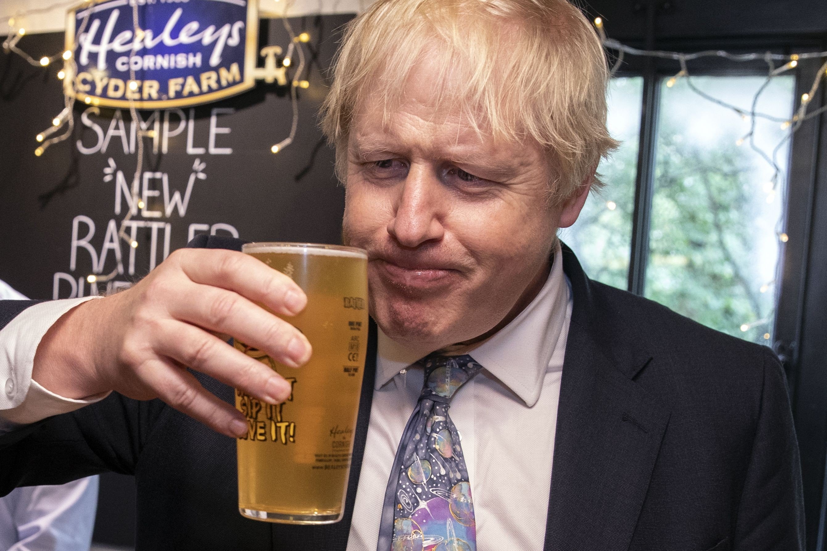 Britain's Prime Minister Boris Johnson takes a sip of cider as he visits Healey's Cornish Cyder Farm in Callestick, Cornwall on Wednesday. Photo: AFP