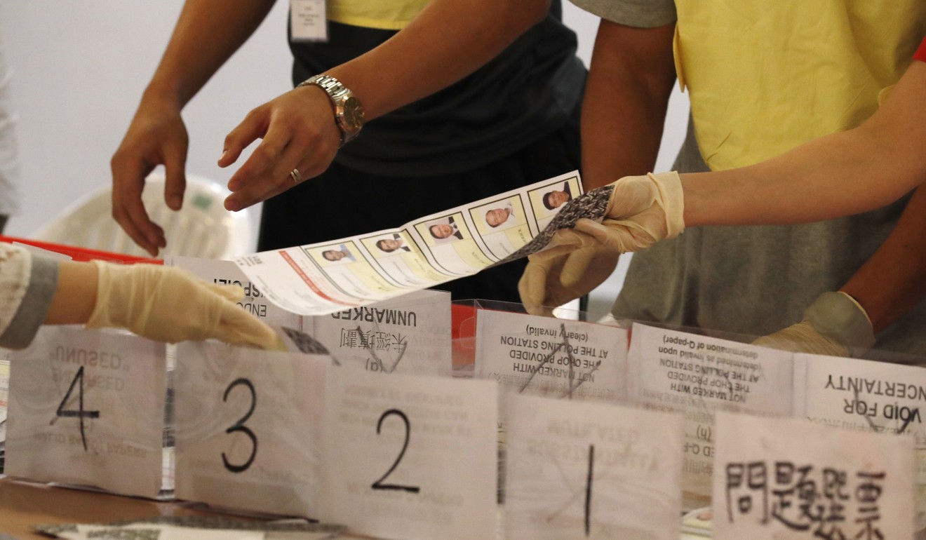 Officials count ballots at a polling station as voting officially closes in Hong Kong. Photo: EPA