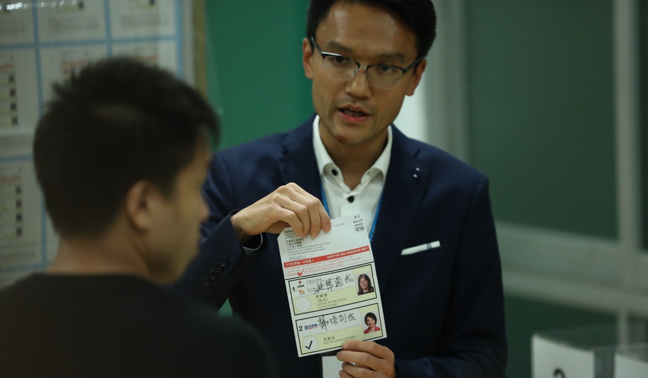 An officer shows a questionable ballot paper at To Kwa Wan North, Kowloon City district. Photo: Sam Tsang