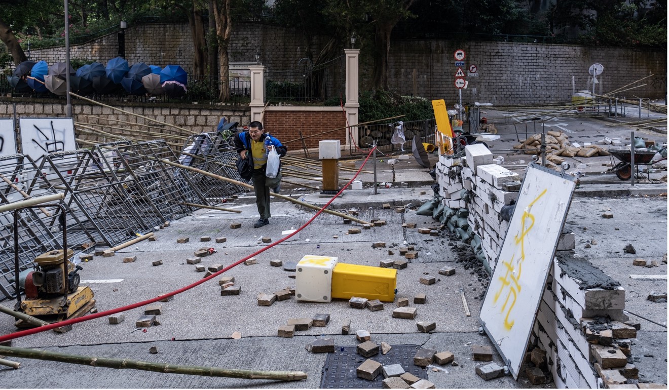 A resident walks through barricades set up near the University of Hong Kong. Photo: Bloomberg