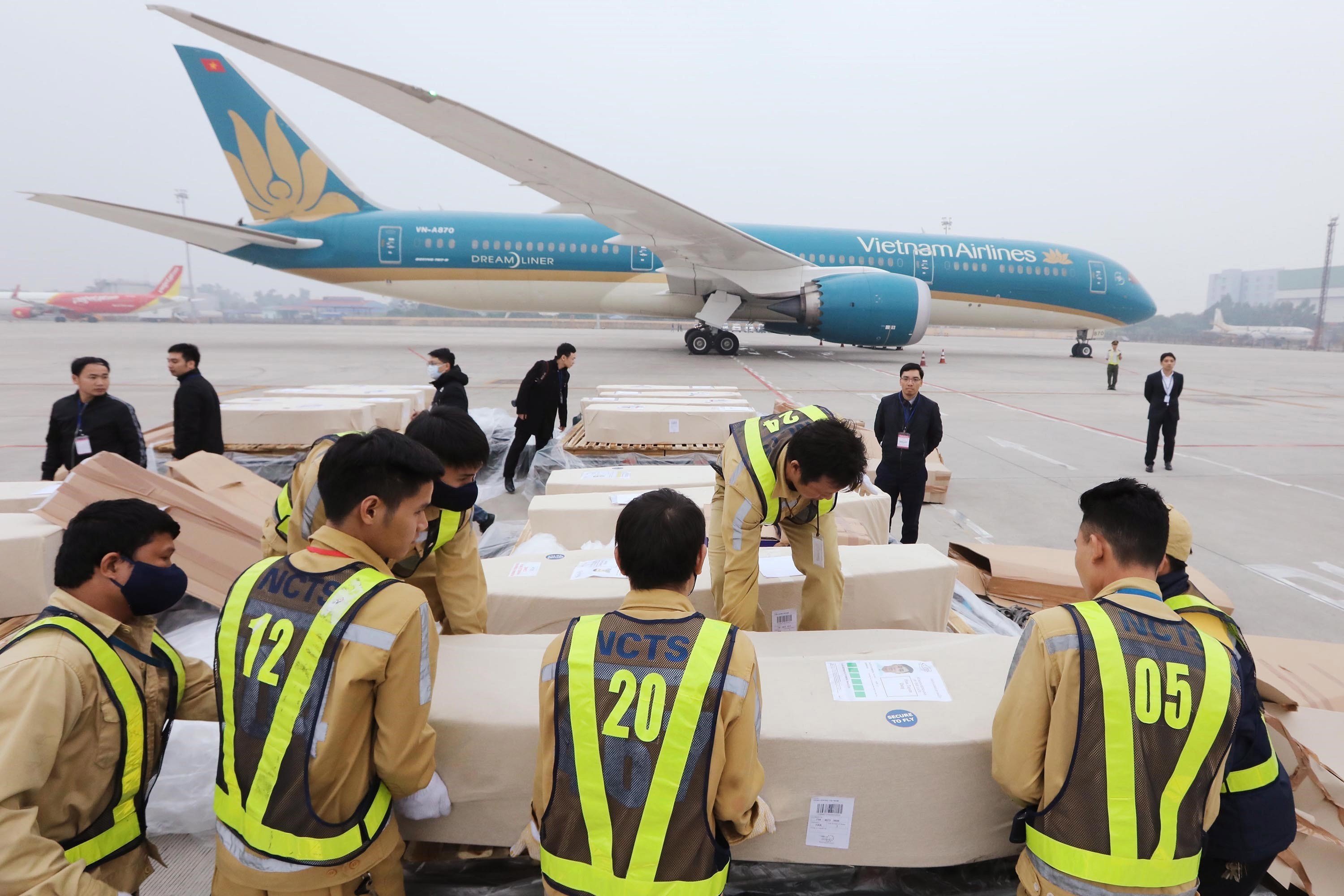 Officials at Noi Bai International Airport in Hanoi, Vietnam, move coffins containing the bodies the victims found dead in a refrigerated truck in Britain. Photo: EPA-EFE