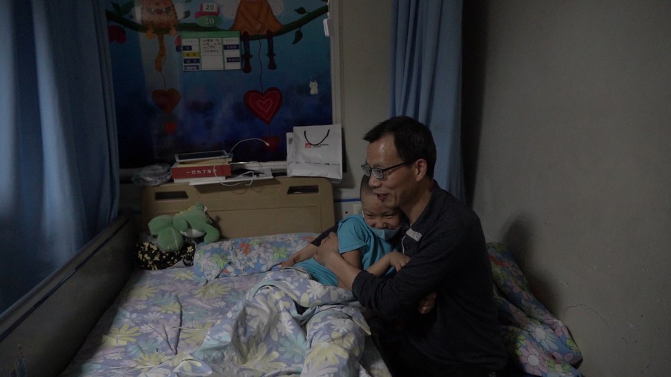 Liu Wei holds his son Liu Xuntao in the children’s cancer ward at Sichuan Provincial People’s Hospital.
