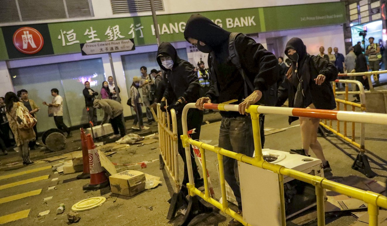 Masked protesters build a barricade outside Mong Kok Police Station and block Prince Edward Road West. Photo: Edmond So