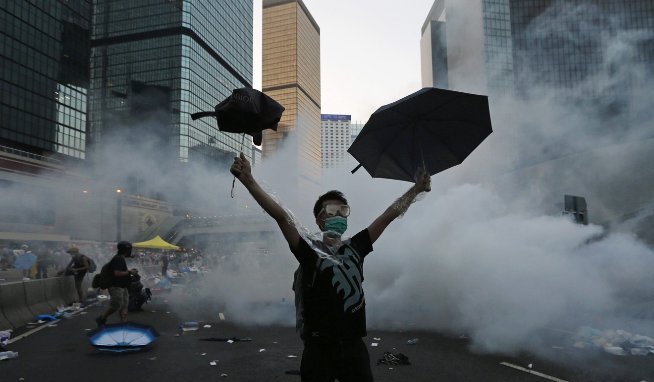 An Occupy protester fights through tear gas fired by riot police outside government headquarters in September 2014. Photo: Reuters