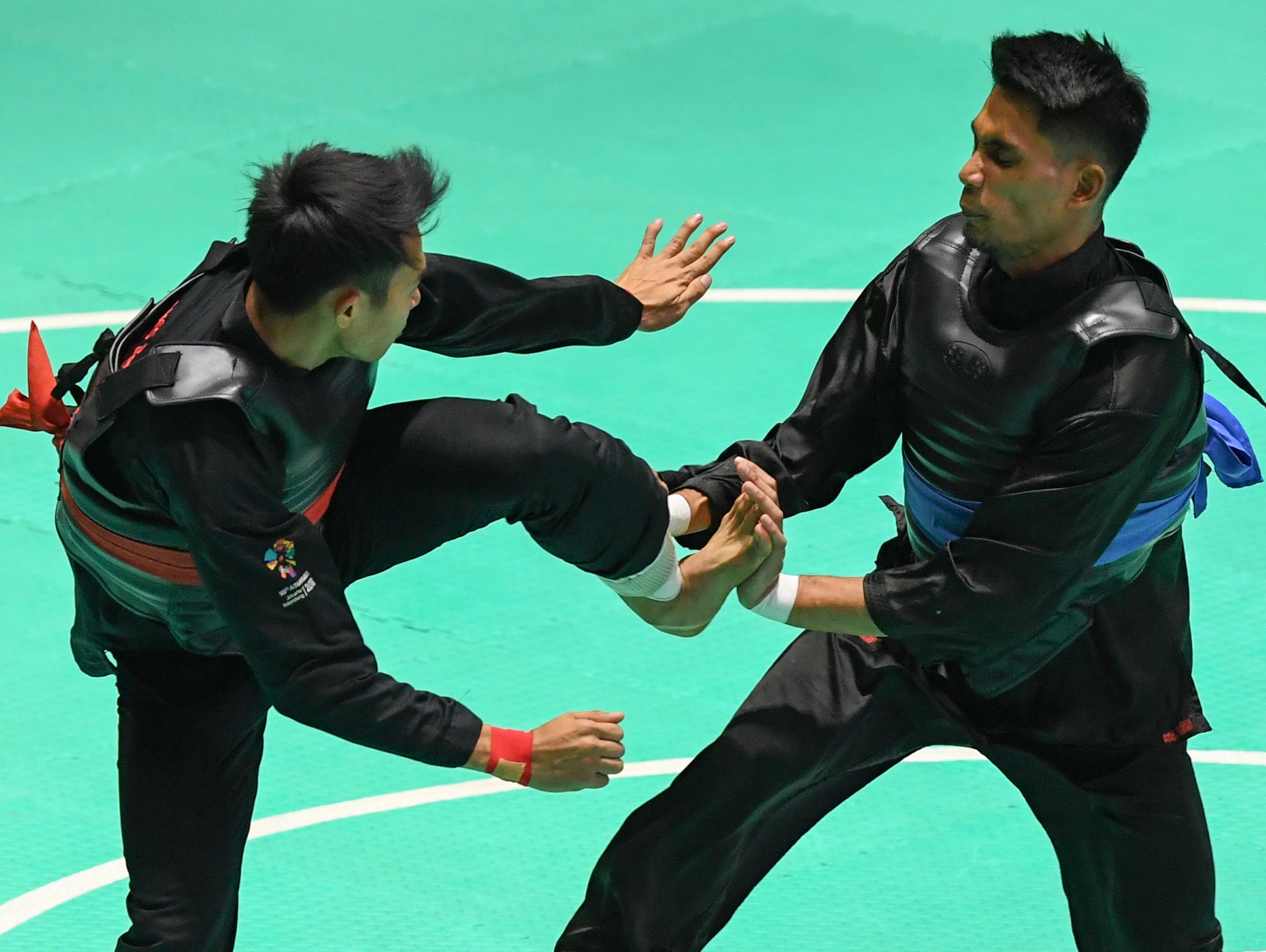 Action from the Pencak Silat at the Asian Games 2018 between Komang Harik Adi Putra (left) of Indonesia and Malaysia’s Mohd Al-Jufferi Jamari. Photo: Xinhua