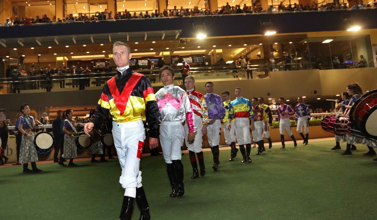 Jockeys enter the track for the IJC at Happy Valley.