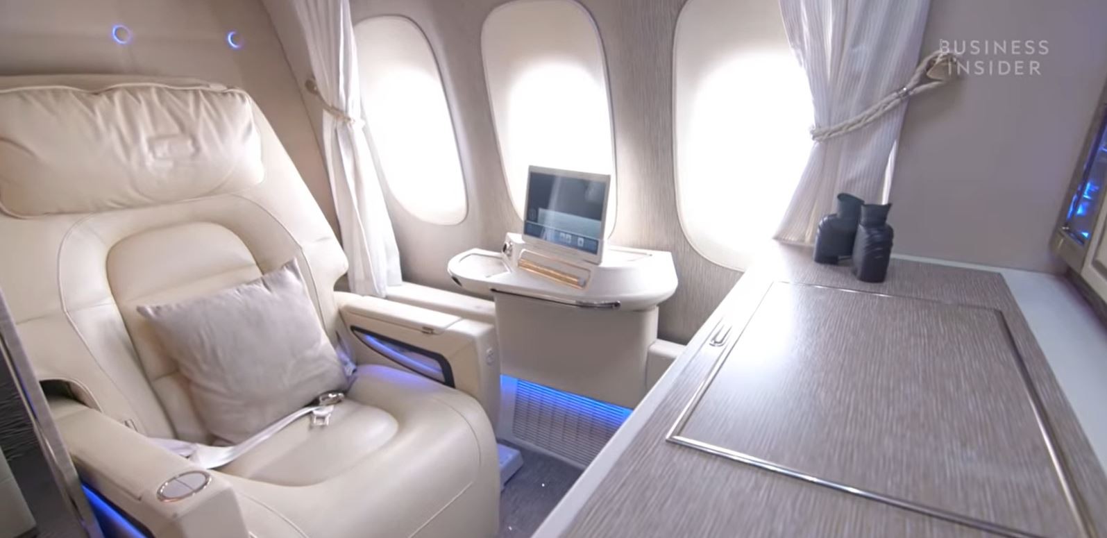 The Emirates’ first-class cabin has a magazine rack, a selection of drinks and snacks, and a 32-inch television. Guests are provided with Bowers & Wilkins E1 headphones. Photo: Business Insider