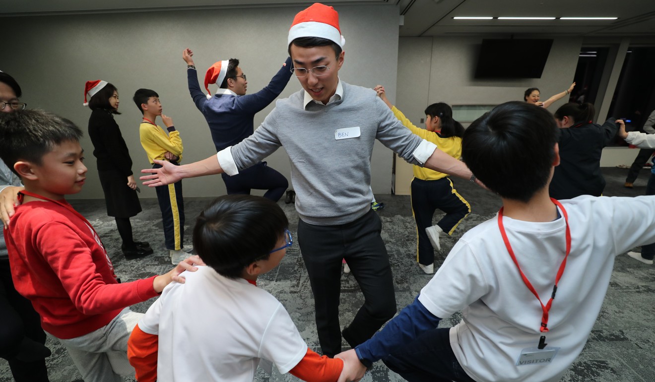 A volunteer guides children at the event hosted by Credit Suisse in West Kowloon. Photo: Edward Wong