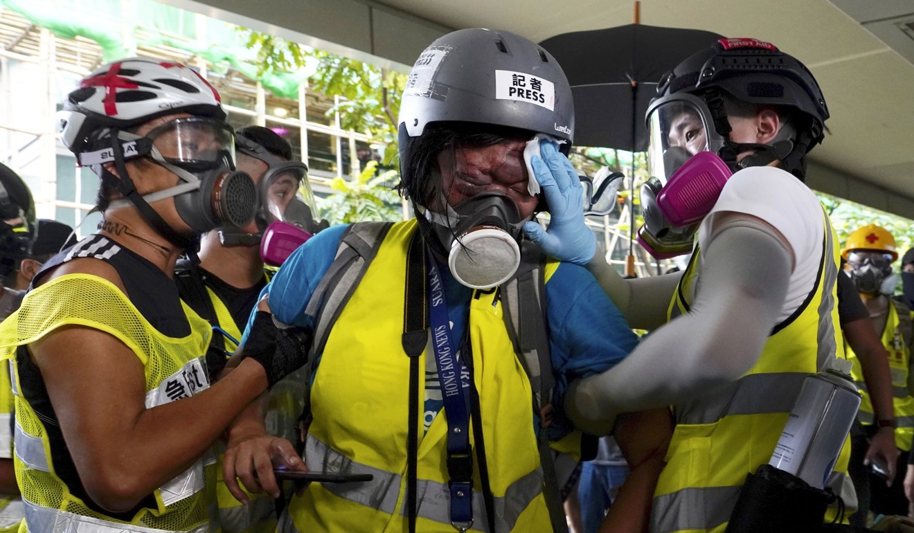 Indonesian journalist Veby Mega Indah, centre, is attended to by others after becoming injured. Photo: AP