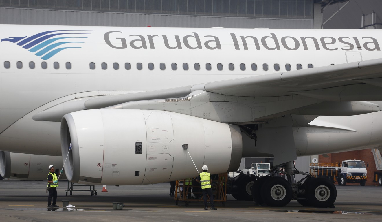 Workers clean a Garuda Indonesia jetliner at Garuda Maintenance Facility in Tangerang, Indonesia. Photo: AP