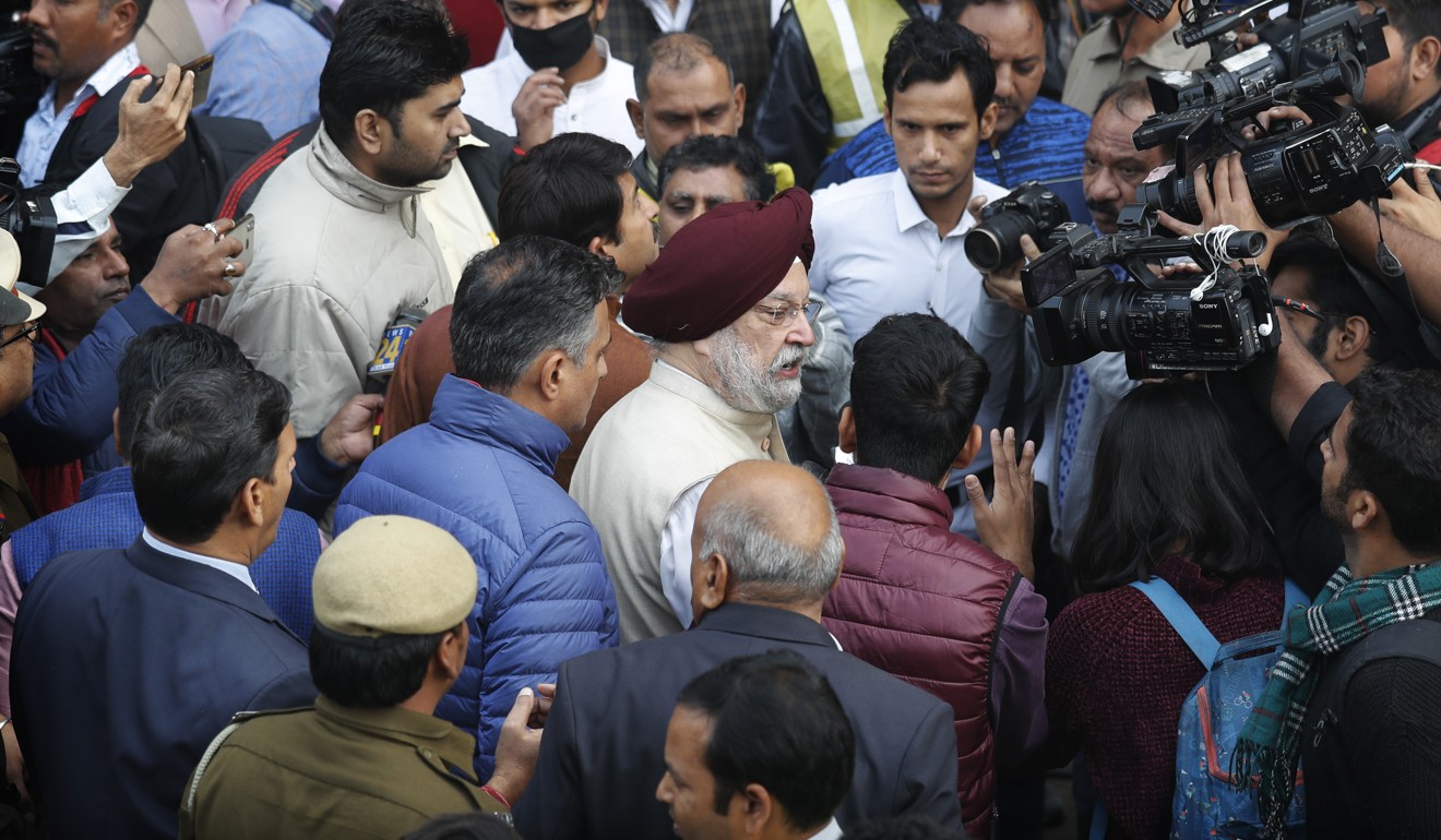 Indian Minister for Housing and Urban Development Hardeep Singh Puri, centre, arrives at the site of a fire. Photo: AP