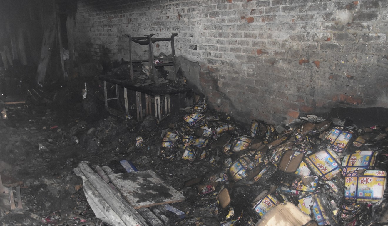 Charred goods are seen inside a factory that caught fire in New Delhi. Photo: AP