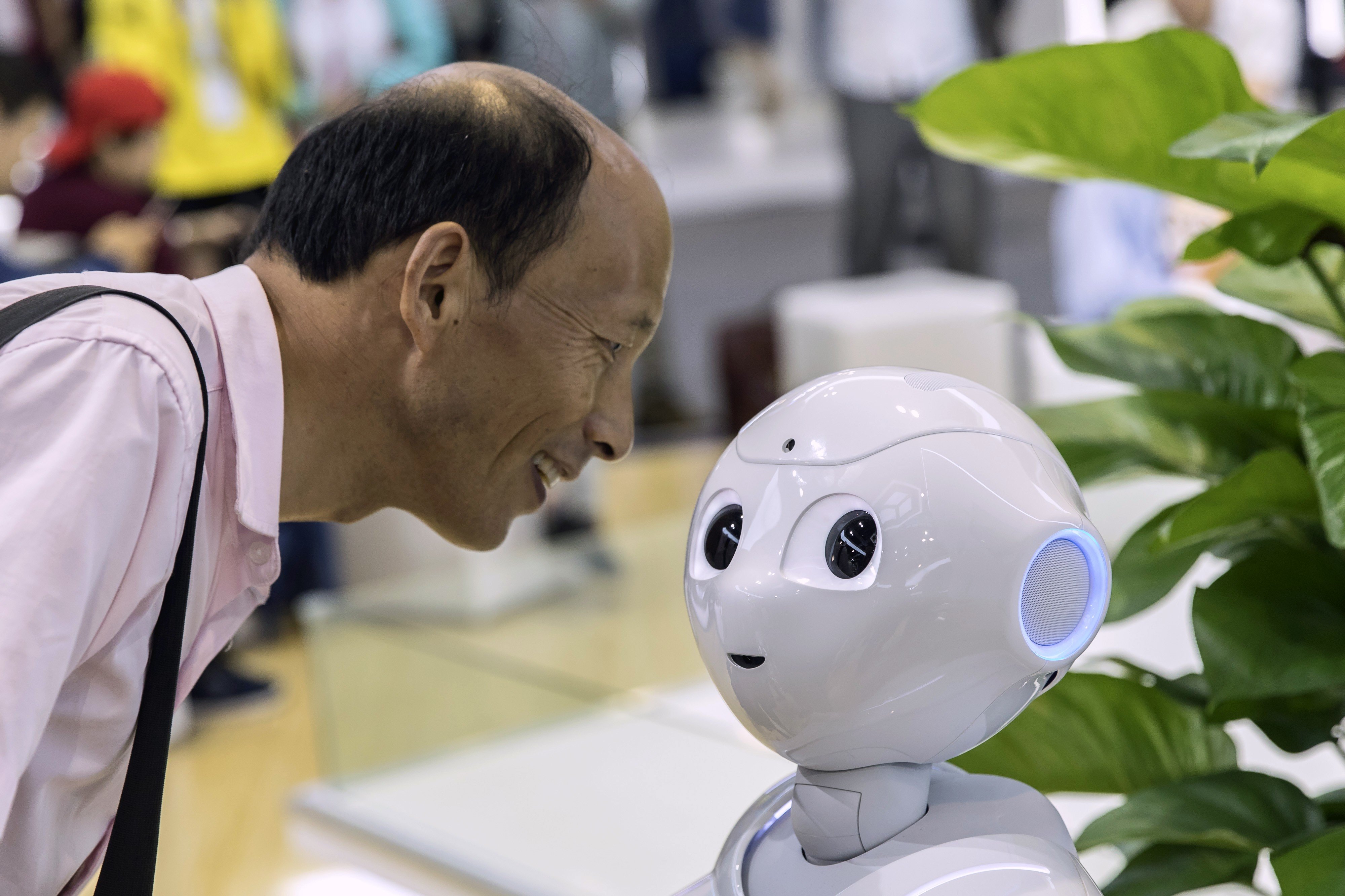 An attendee inspects Pepper, a semi-humanoid robot, at the World Artificial Intelligence Conference in Shanghai on August 29. Photo: Bloomberg