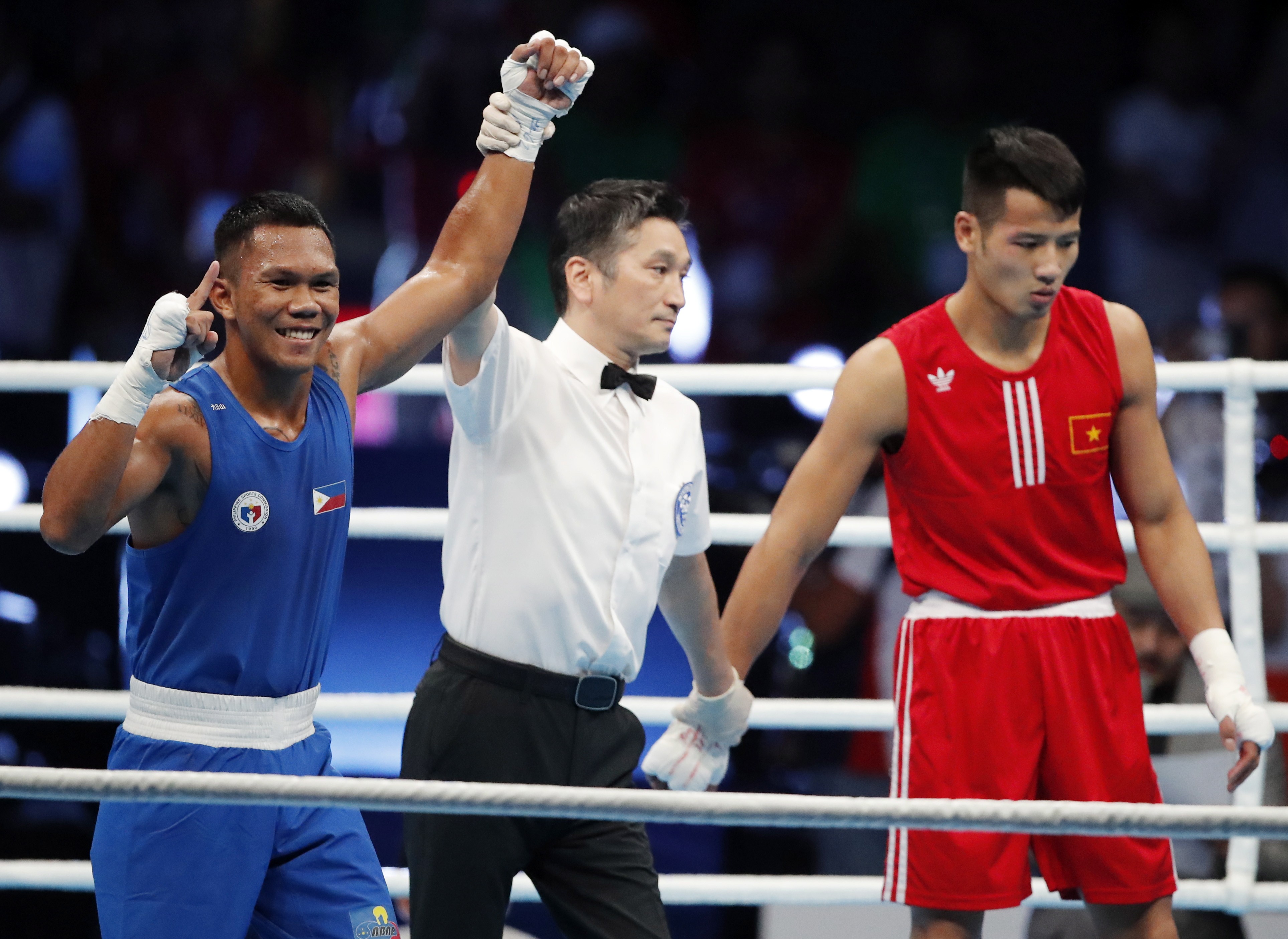 Eumir Marcial (left) has his arm raised after a first-round knockout in the men’s boxing middleweight final in Manila, the Philippines. Photo: EPA