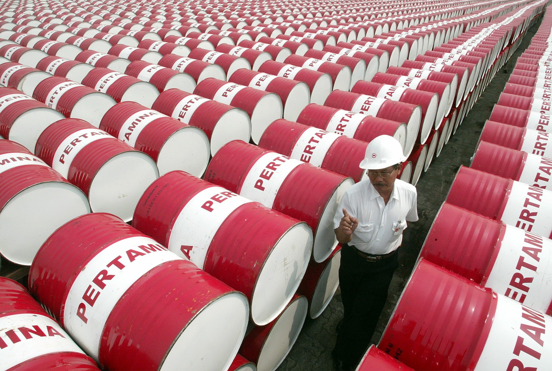 An employee of Indonesia’s state-owned oil company Pertamina walks past oil drums at the company’s main depot in north Jakarta. Photo: Reuters