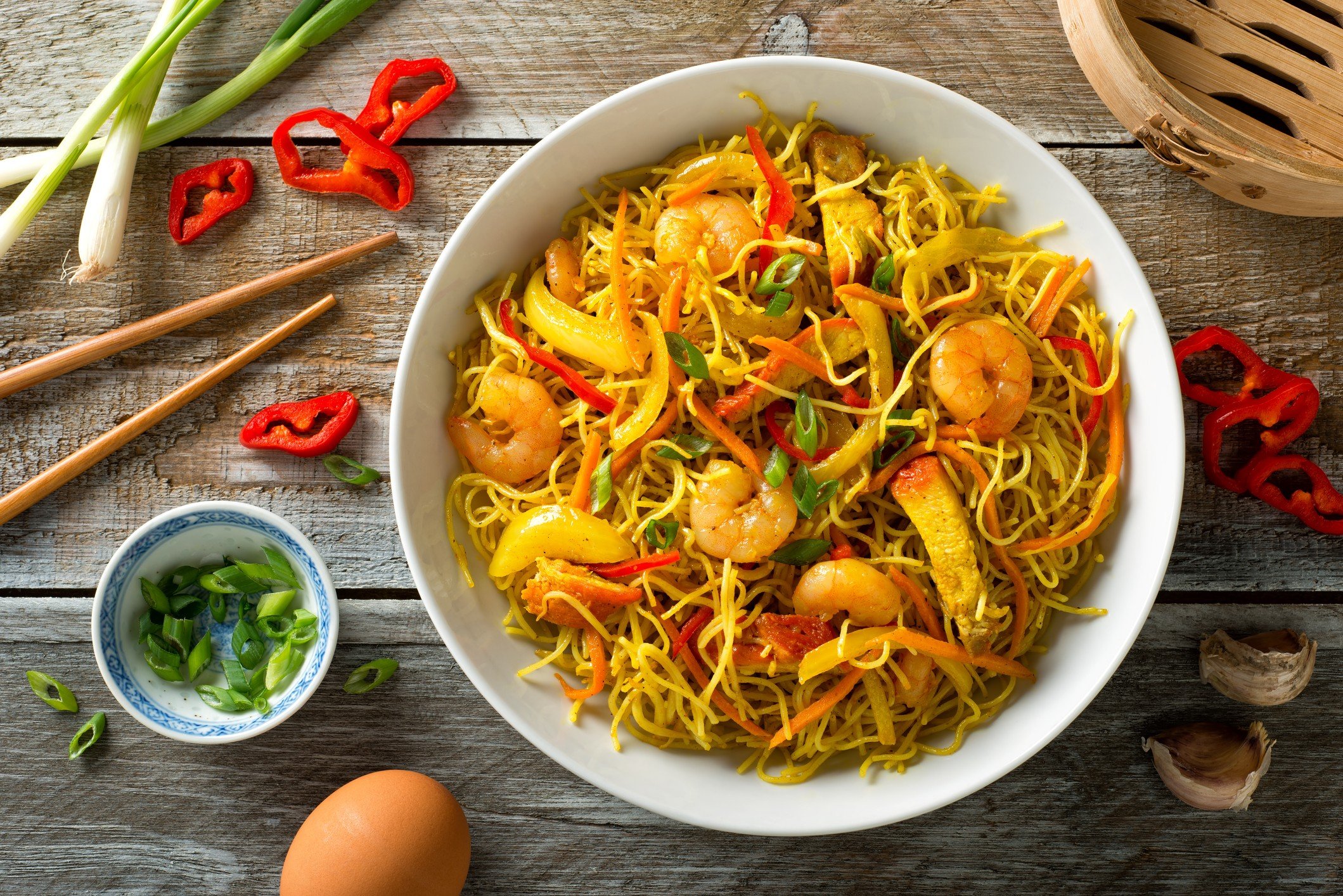 Delicious Singapore-style noodles, comprising curry, shrimp, barbecued pork, carrots, red pepper, onion and scallions, doesn’t come from its purported country of origin.