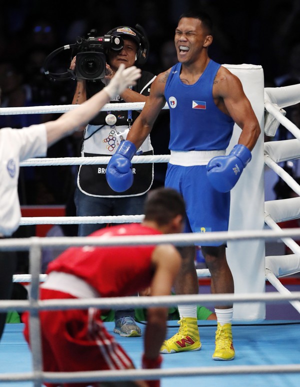 Felix Eumir Marcial of Philippines waits in his corner as Manh Cuong Nguyen recovers from a knock down in the gold medal match. Photo: EPA
