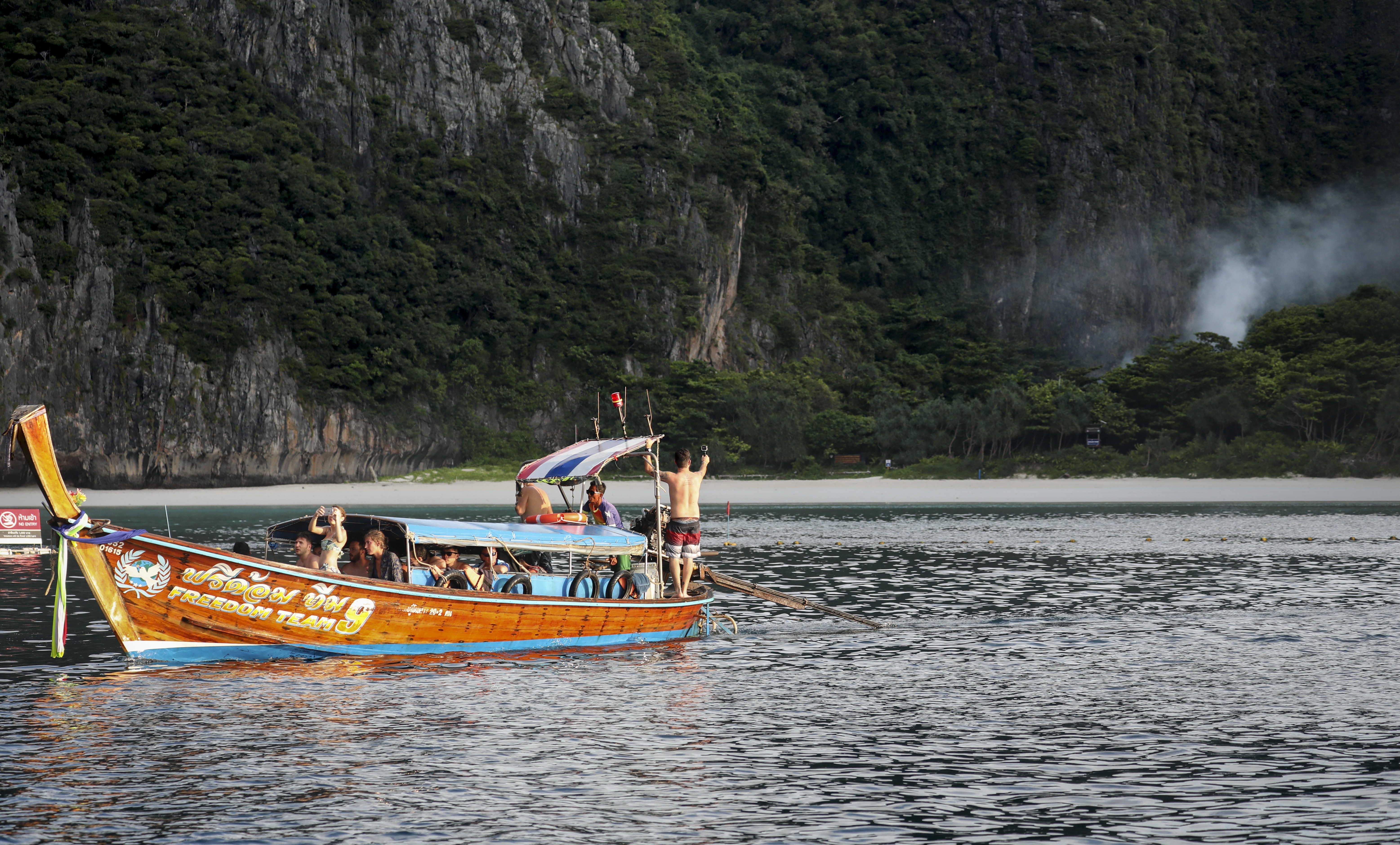Tourists on a long-tail boat look longingly towards Maya Bay, Ko Phi Phi Lee, Thailand. Photo: James Wendlinger