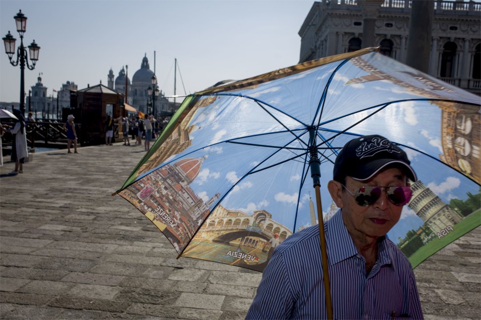 A Chinese tourist in St Mark’s Square, Venice. Photo: Corbis via Getty Images