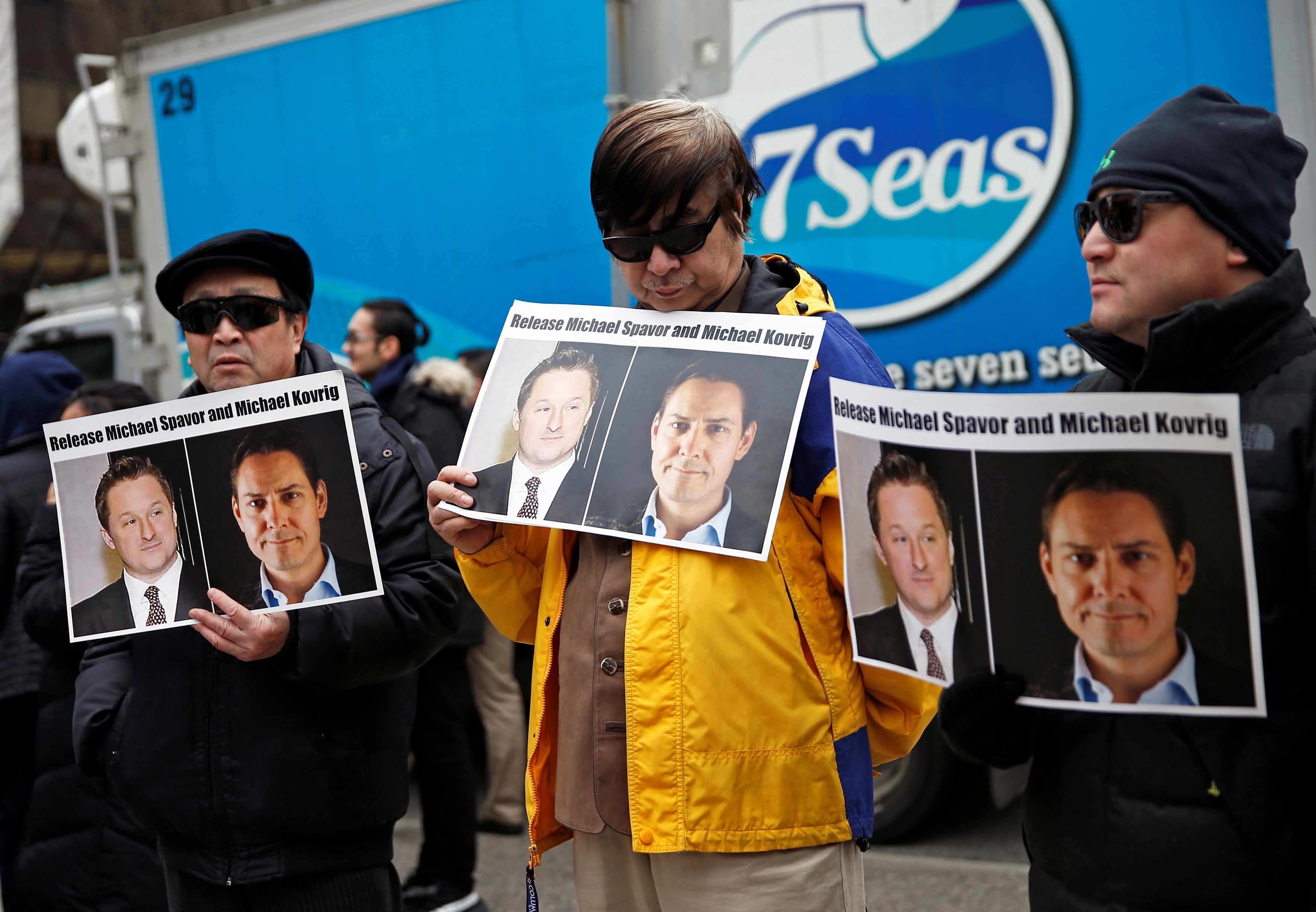 People hold placards calling for China to release Michael Spavor and Michael Kovrig outside a court hearing for Huawei executive Meng Wanzhou in Vancouver in March. Photo: Reuters