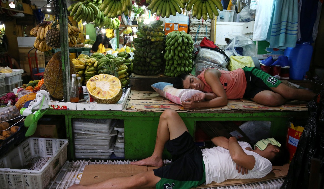 Workers sleep at a stall in a farmers’ market in Quezon City, Metro Manila. Photo: Reuters