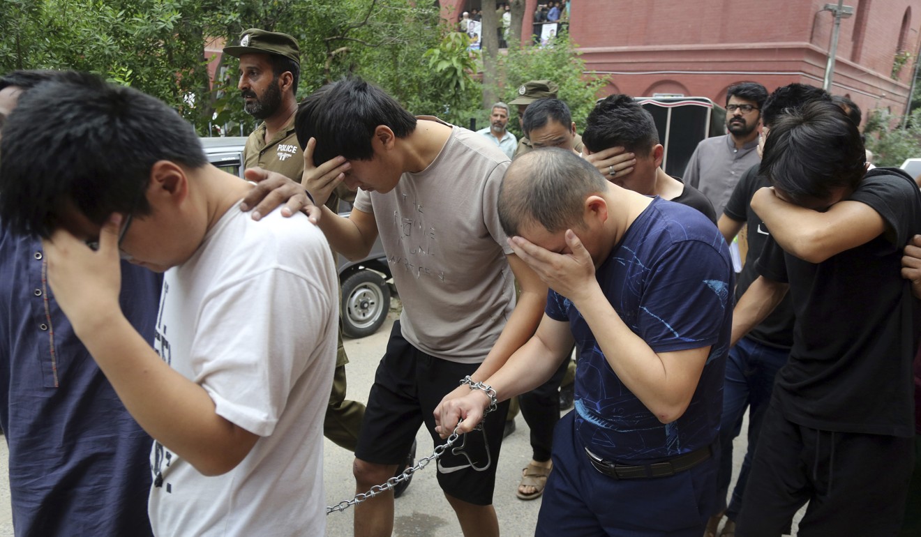 Detained Chinese nationals, accused of involvement in a trafficking gang to lure Pakistani women into fake marriages, arrive at a court in Lahore in May. Photo: AP