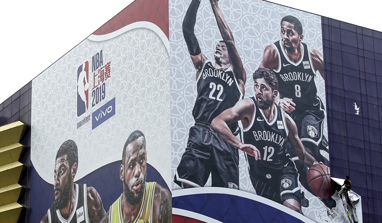 A worker takes down a billboard advertising an NBA preseason game between the Los Angeles Lakers and Brooklyn Nets in Shanghai after comments by the manager of a different team prompted a fierce backlash in China. Photo: AP