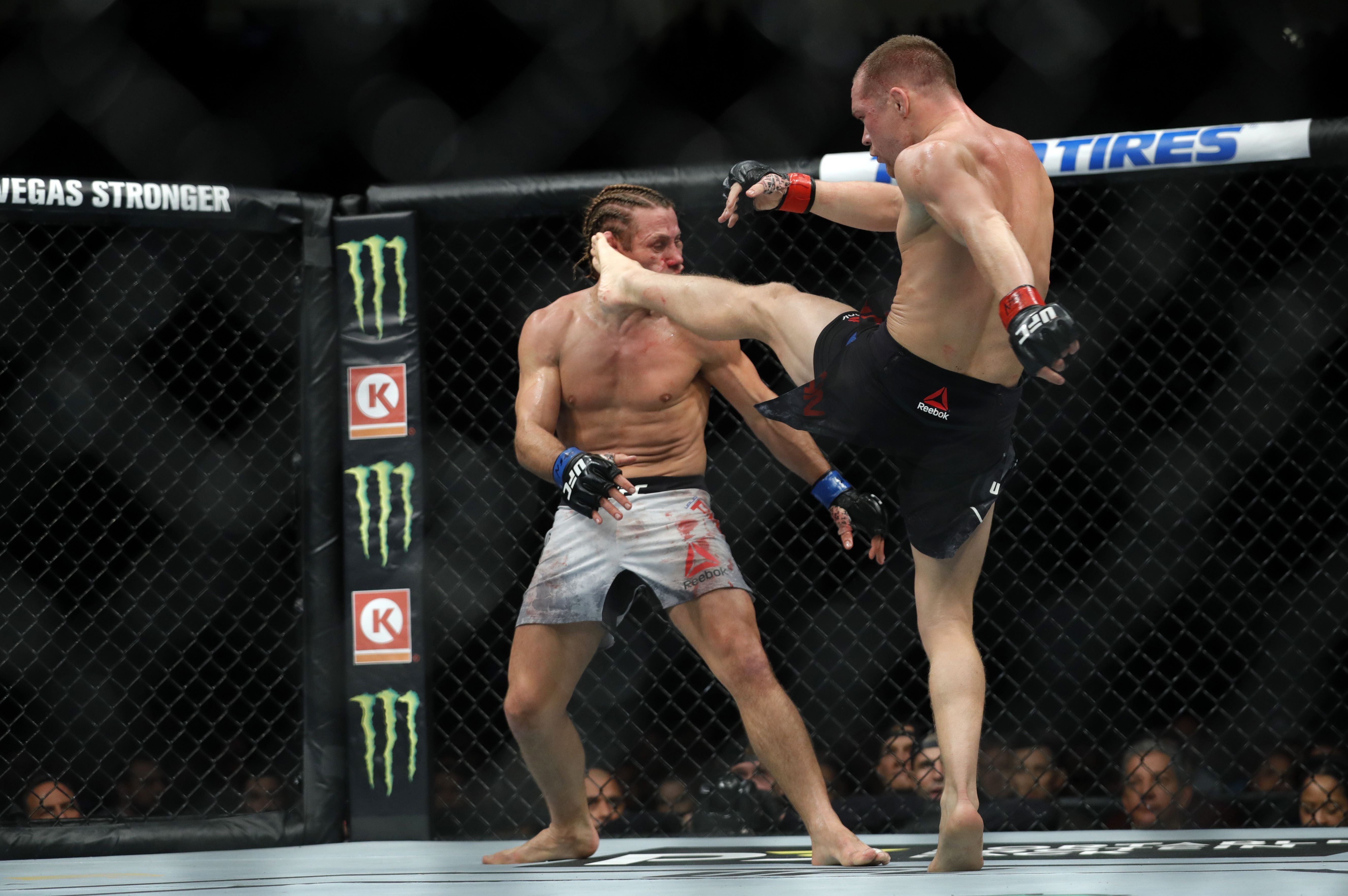 Petr Yan lands a kick on Urijah Faber that sends him to the canvas in the third round of their bantamweight fight during UFC 245. Photo: AFP