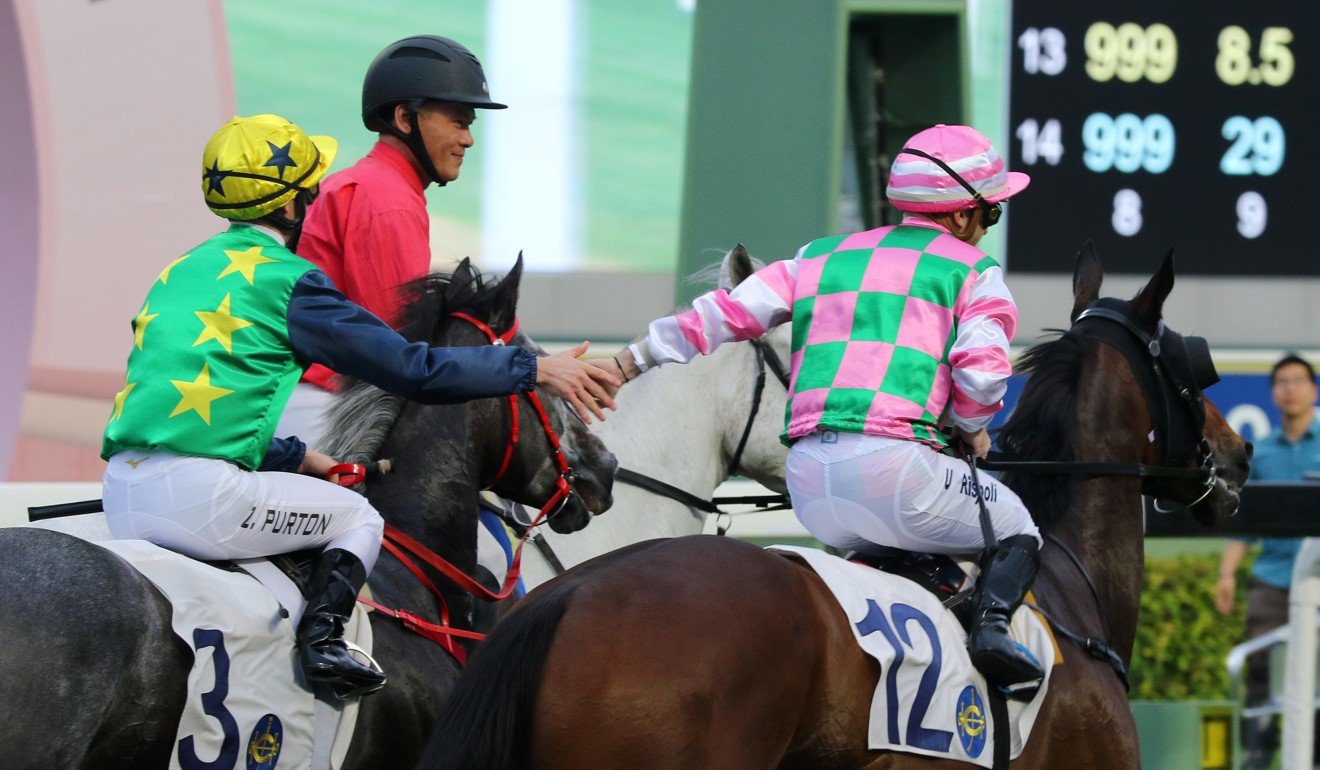 Zac Purton (left) high-five’s Umberto Rispoli (right) after his final ride in Hong Kong.