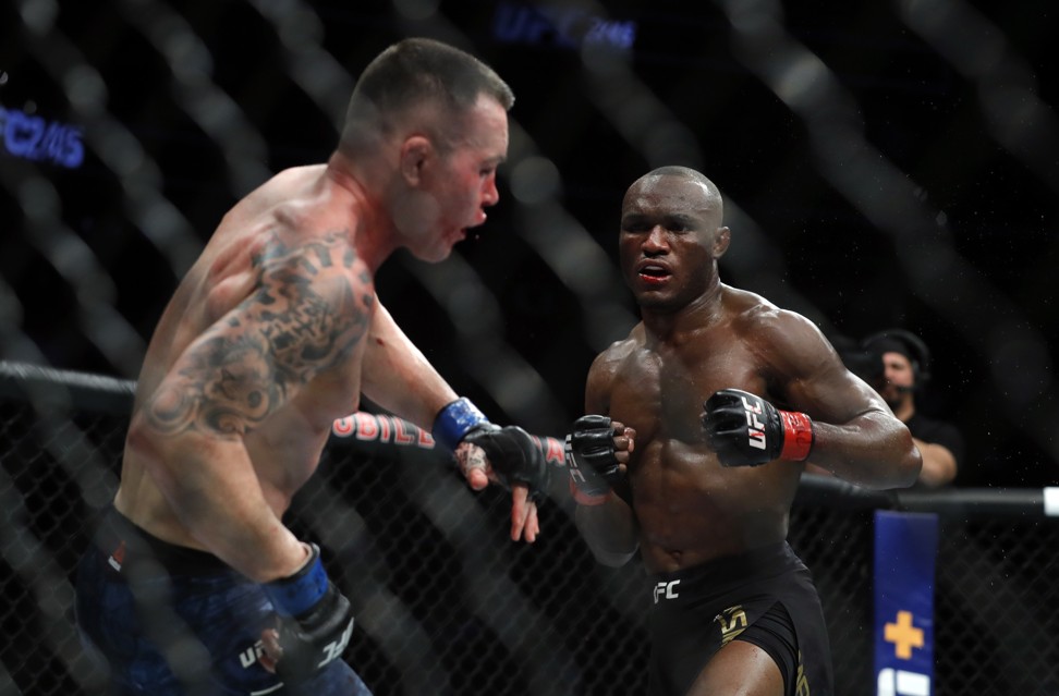 Colby Covington falls back from a punch by UFC welterweight champion Kamaru Usman. Photo: AFP