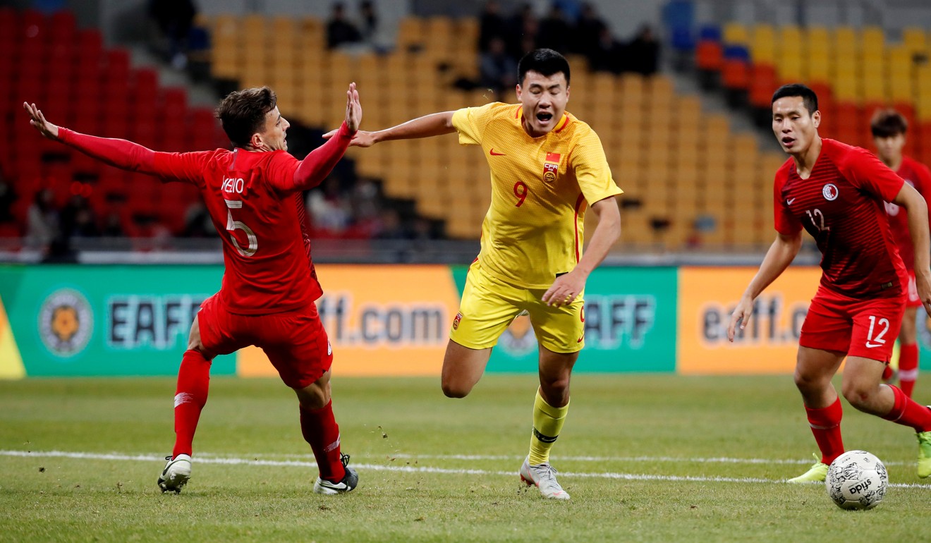 China's Xuesheng Dong (centre) is fouled by Hong Kong's Helio ahead of the second goal. Photo: Reuters