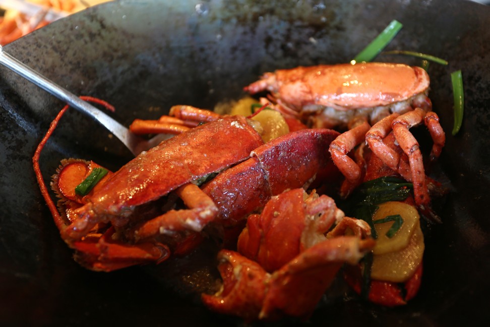 Add the lobster to the wok with ginger and spring onions. Photo: Jonathan Wong