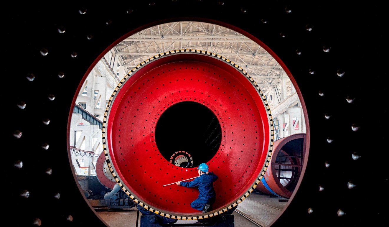 An employee measures a newly manufactured ball mill machine at a factory in Nantong, Jiangsu province, China, on June 28. Photo: Reuters