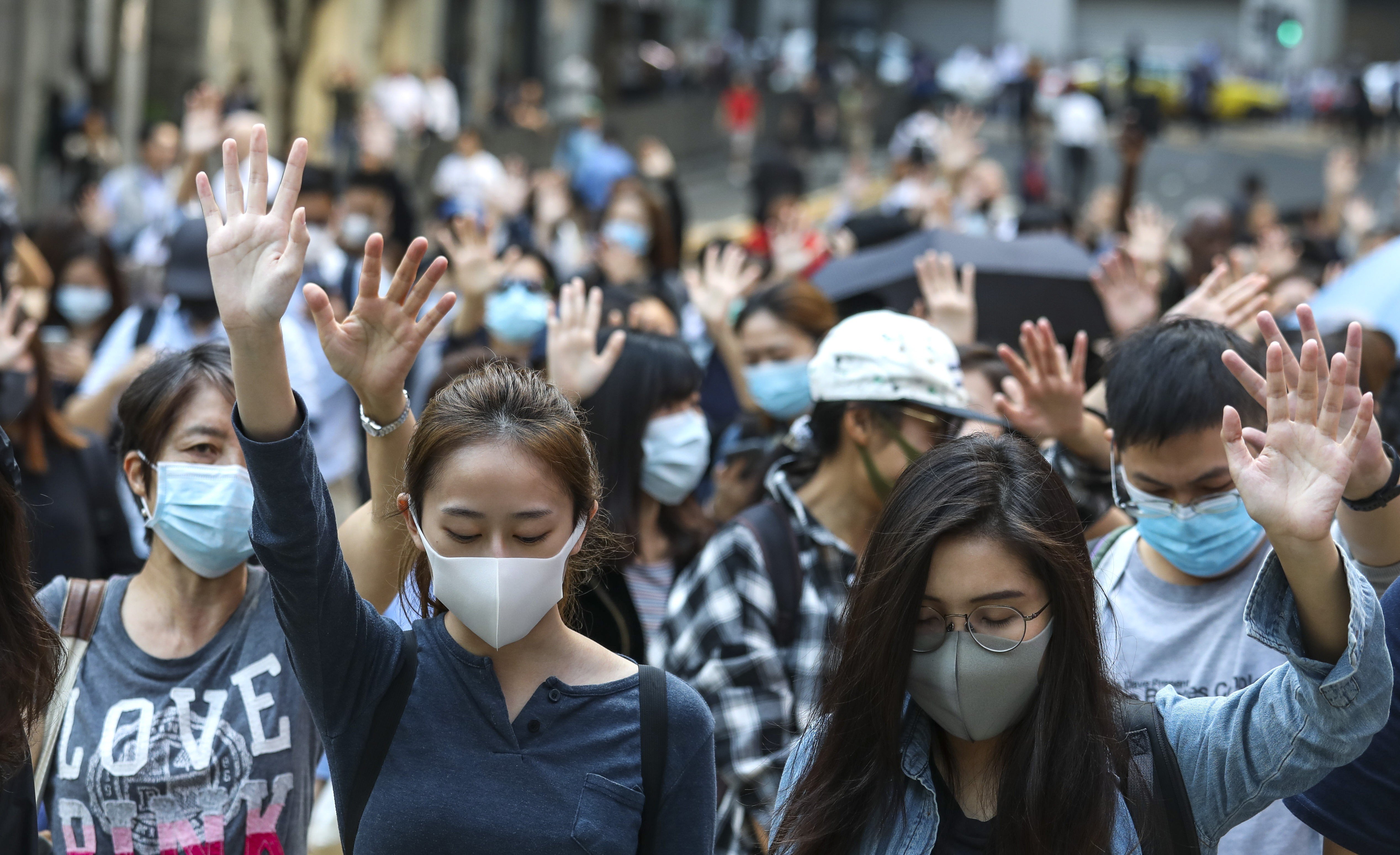 Hong Kong protesters, mostly officer workers, hold up five fingers to symbolise their five demands including universal suffrage, during a lunch-hour rally in Central on November 13. Photo: Nora Tam