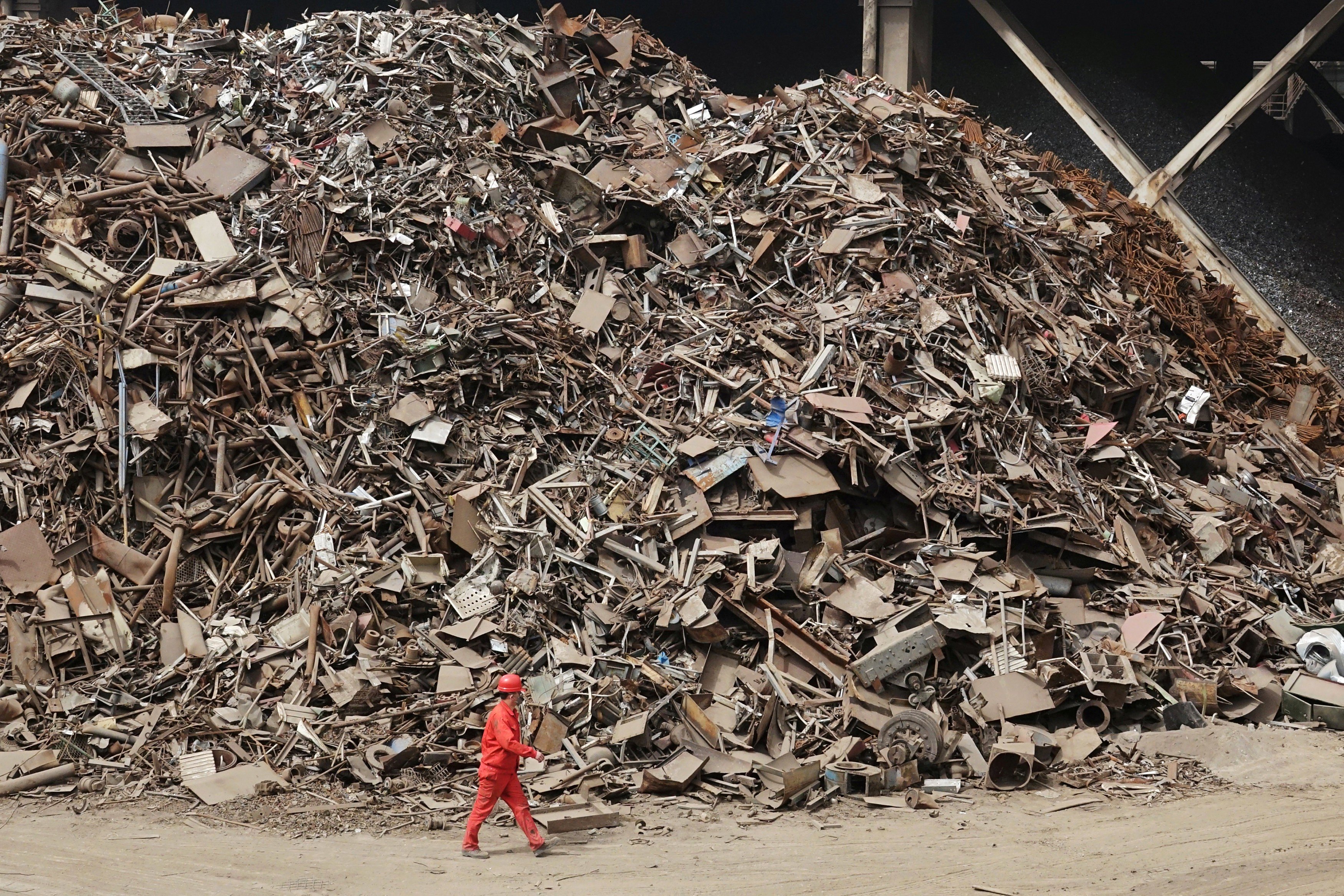 A worker walks past piles of scrap steel at a plant of Dongbei Special Steel Group in Dalian, Liaoning province, in March 2018. The company failed to repay 10 batches of corporate bonds worth US$1 billion from March 2016 onwards, leading to a legal battle between the company and its 1,911 creditors. After a court-ordered “bankruptcy restructuring” plan in which creditors lost 78 per cent of their money, and a windfall from a steel price rally, the company bounced back. Photo: Reuters