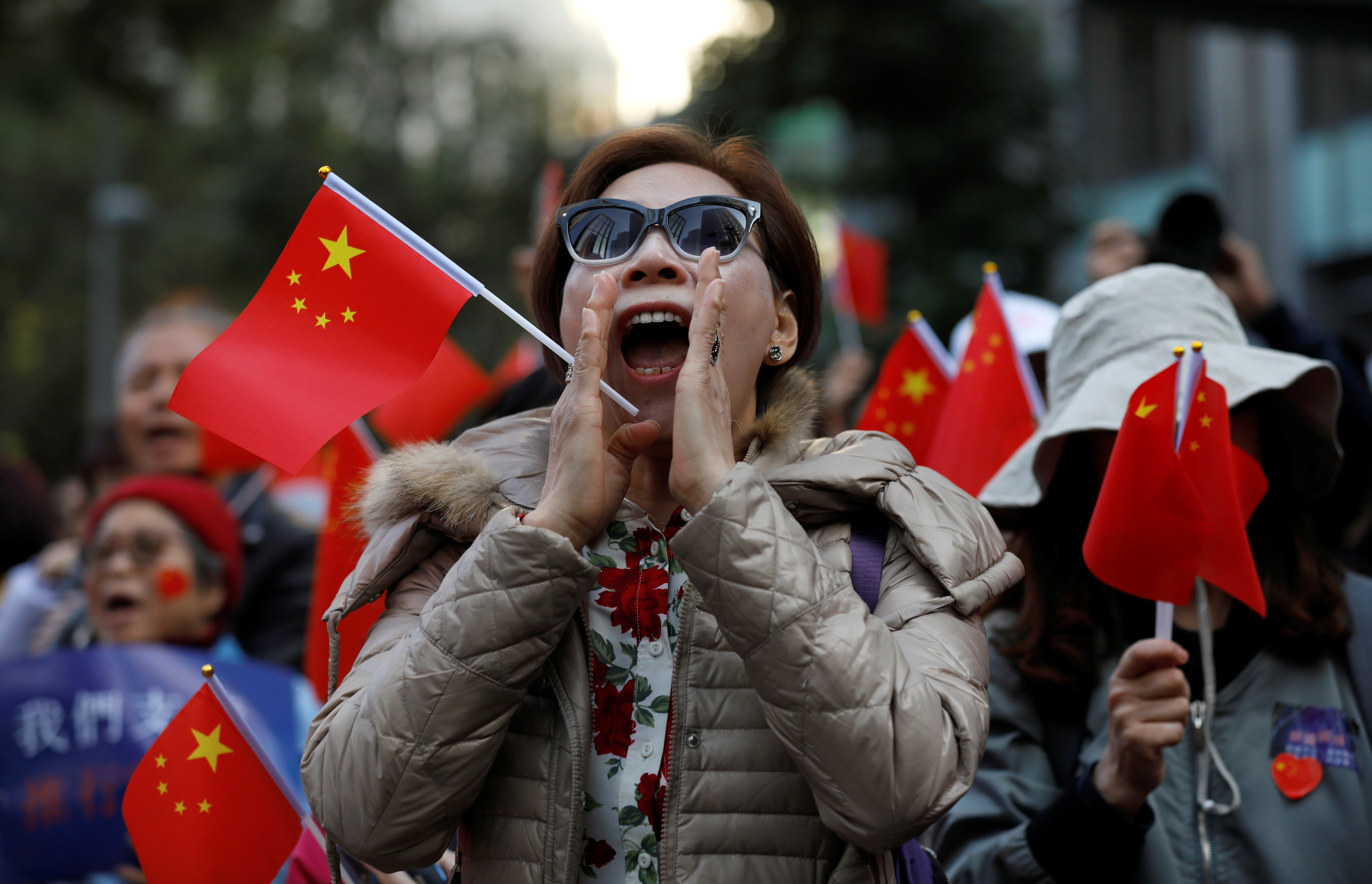 A pro-Beijing demonstrator shouts slogans as she holds a Chinese flag during a rally in Hong Kong on December 7. Photo: Reuters