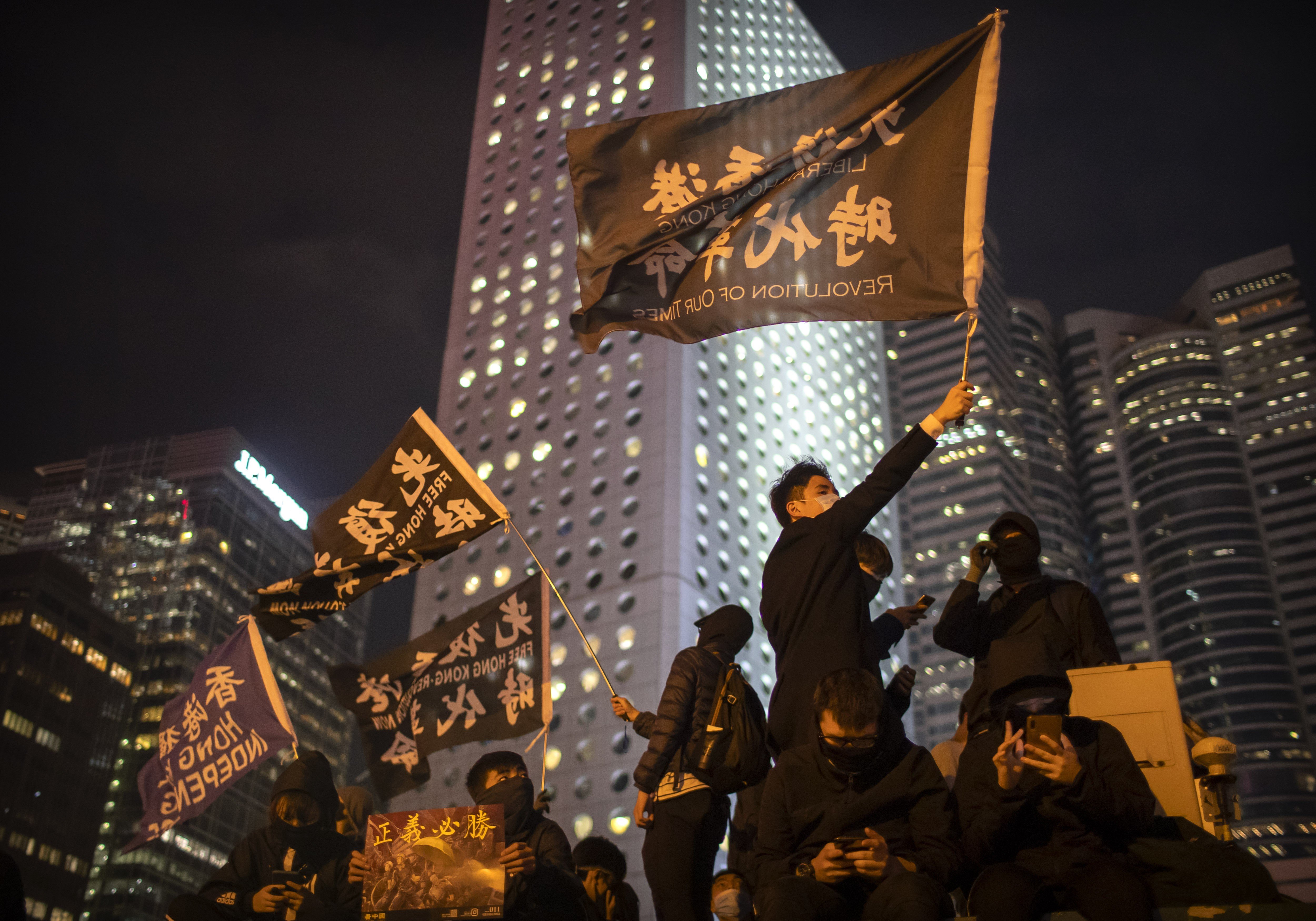 A protester holds a flag that reads: “Liberate Hong Kong, revolution of our times” at a rally in Hong Kong on December 12. Photo: AP
