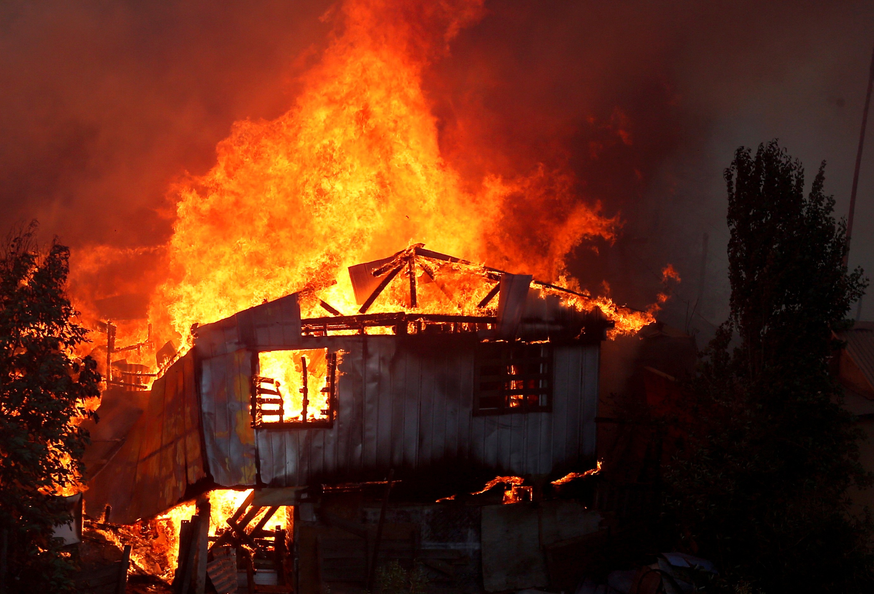 A house burns as a fire spreads in Valparaiso, Chile, on Tuesday. Photo: Reuters