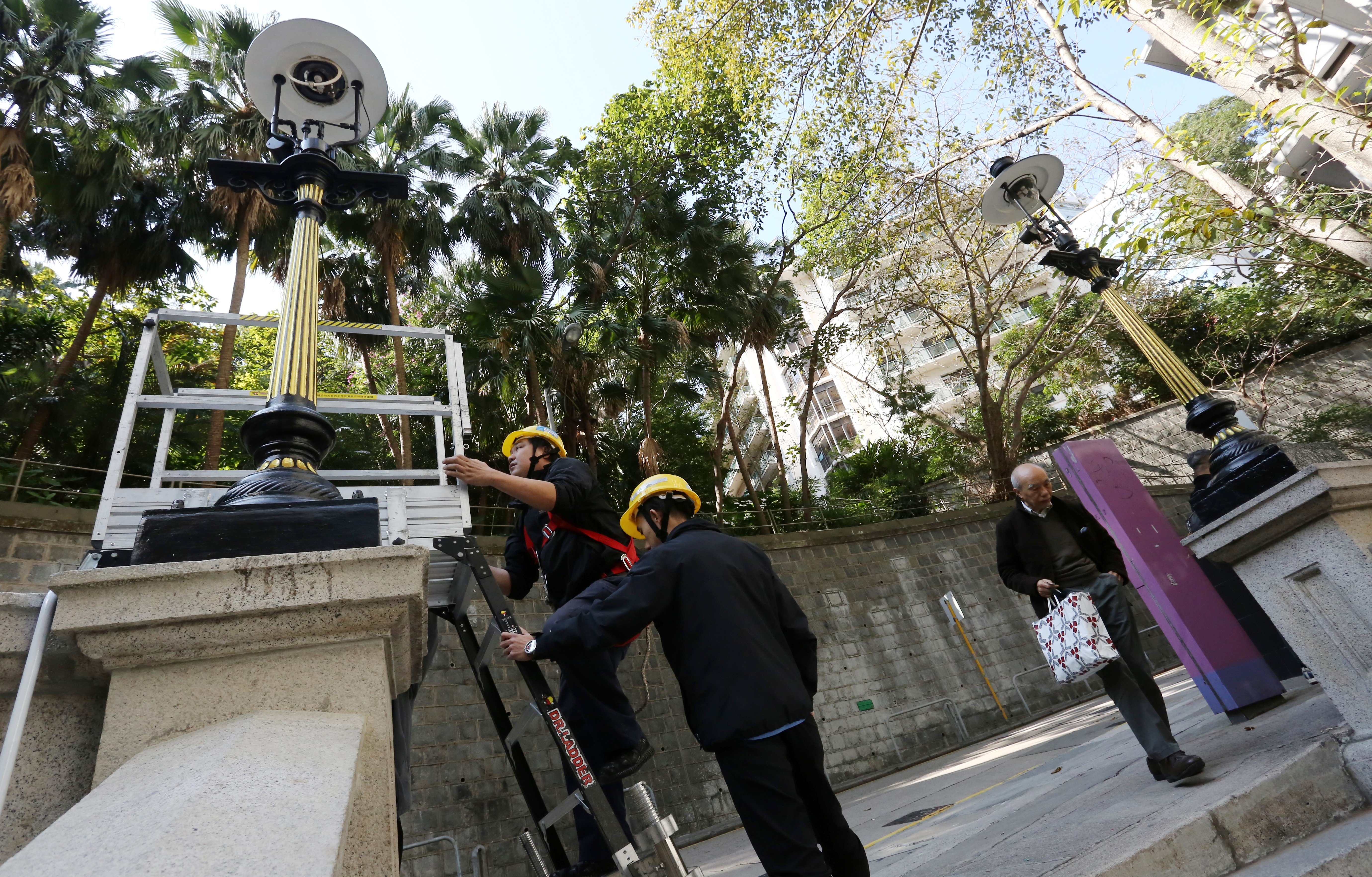 Workers from Towngas complete the reinstallation of street lamps on Duddell Street, Central. Photo: Jonathan Wong