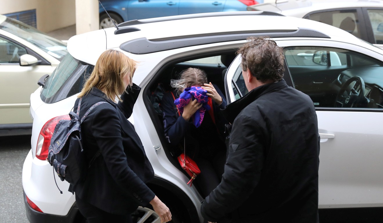 The British woman, and alleged victim of a gang rape, covers her face as she arrives at a court in Cyprus on Monday. Photo: Reuters