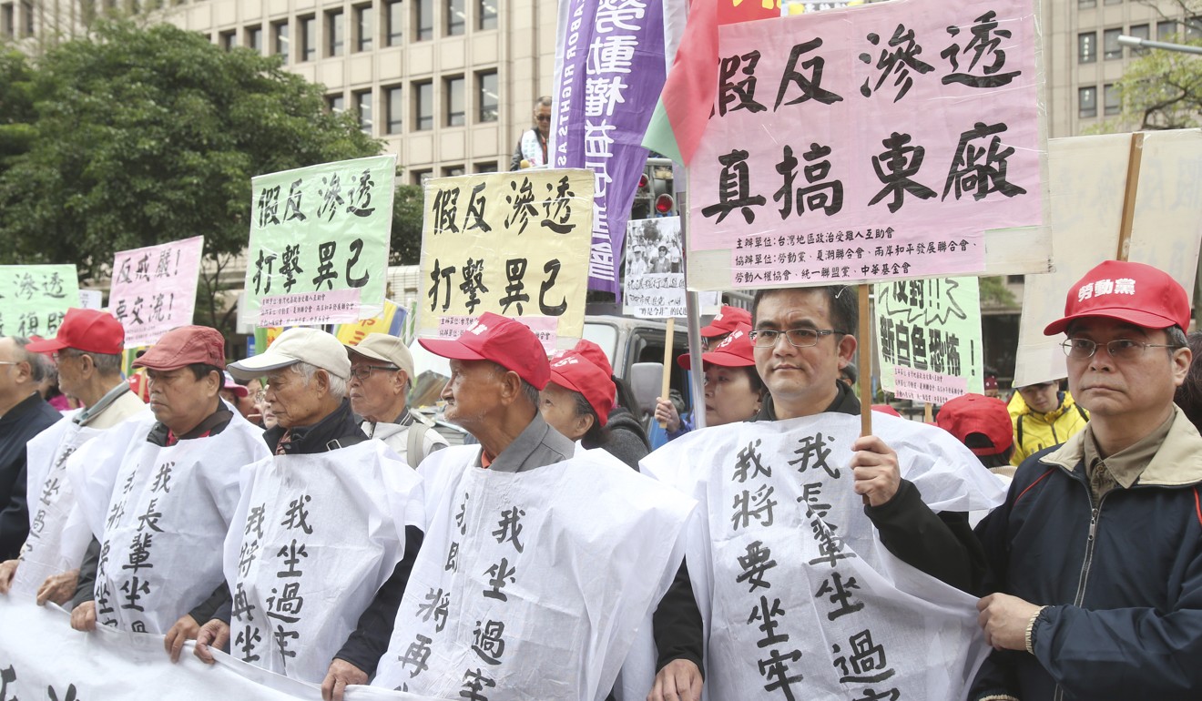 Protesters hold slogans against the anti-infiltration bill outside the legislature in Taipei on Tuesday. Photo: AP