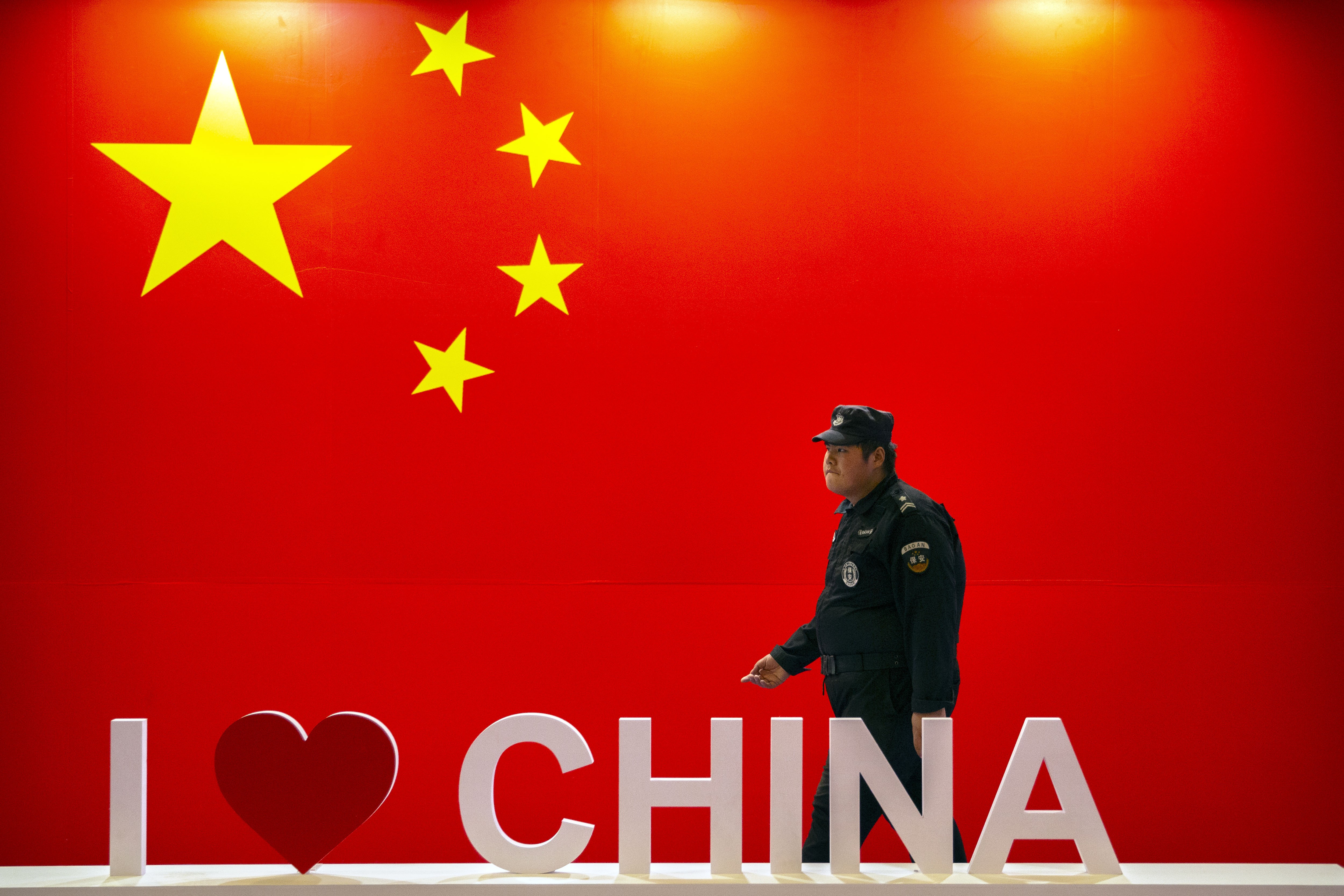 A security officer walks past a display with the Chinese flag at a technology expo in Beijing on October 31, 2019. The US-China trade war has given expression to many global anxieties about China’s rise. Photo: AP