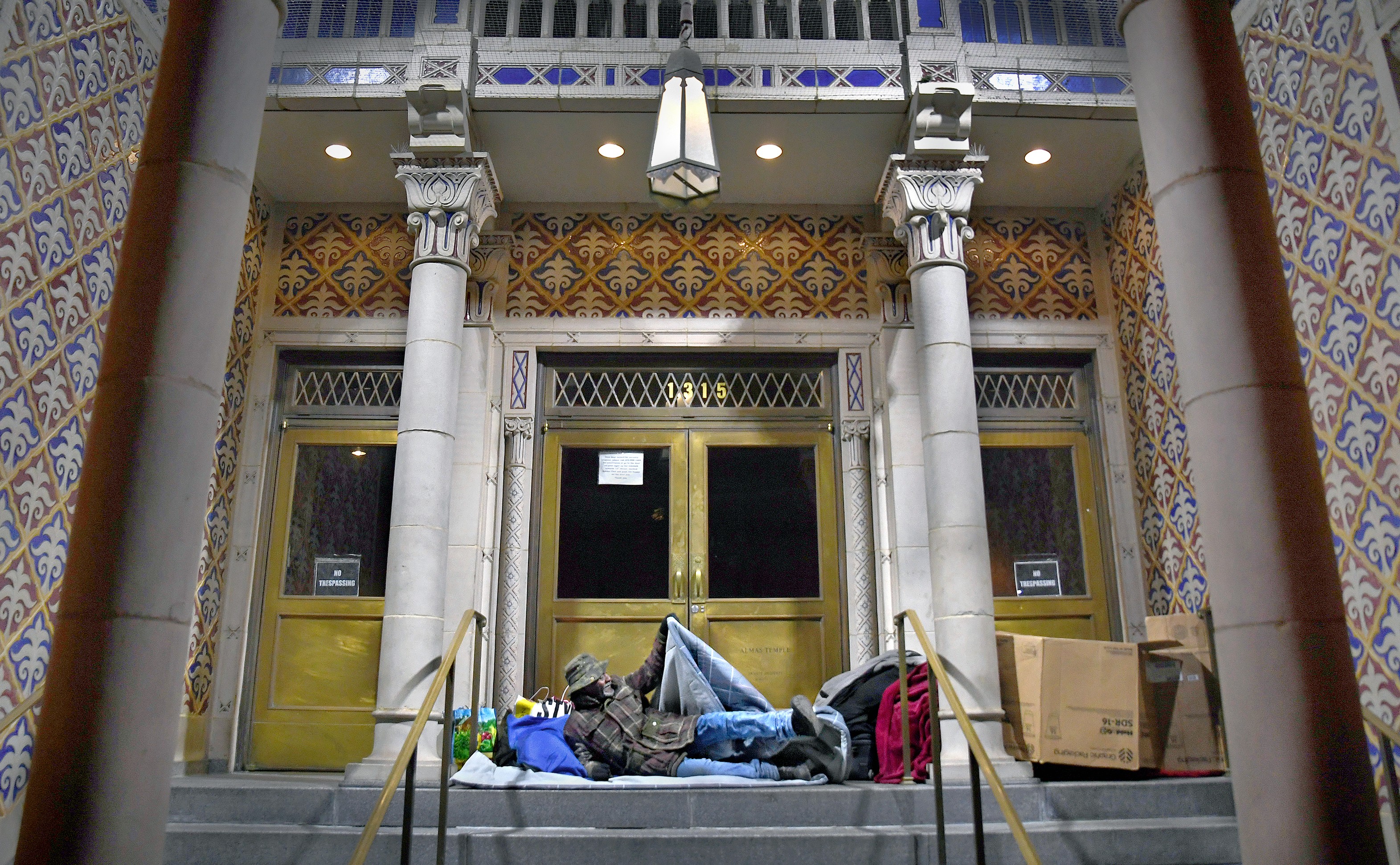 A homeless man in Washington D.C. beds down for the night opposite Franklin Square park on the steps of the Sphinx Club at Almas Temple. Donald Trump’s cuts to social spending, while raising the defence budget and offering tax cuts that benefit the rich, have contributed to increased inequality. Photo: Washington Post