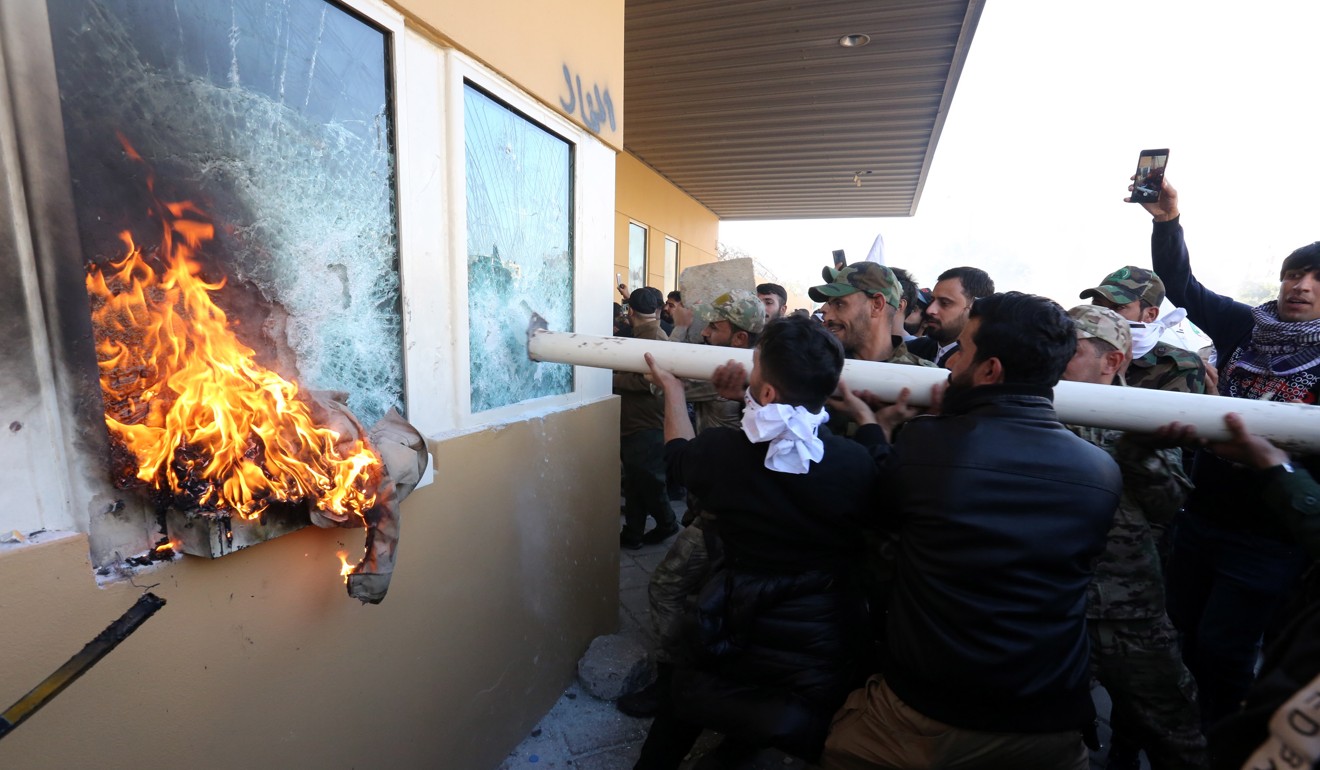 Protesters attack the entrance of the US embassy in Baghdad. Photo: EPA